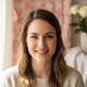 Portrait of a smiling young North American woman with warm features, looking calm and relieved.