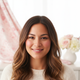 Portrait of a smiling North American woman in her late 20s with diverse features, looking comfortable and relieved.